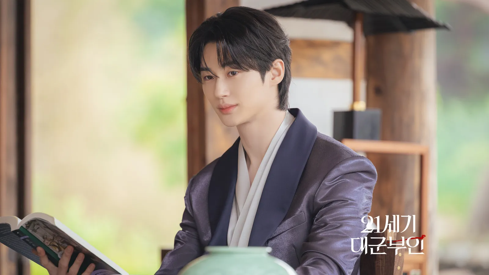 Prince I-an reading in traditional hanbok at a palace pavilion